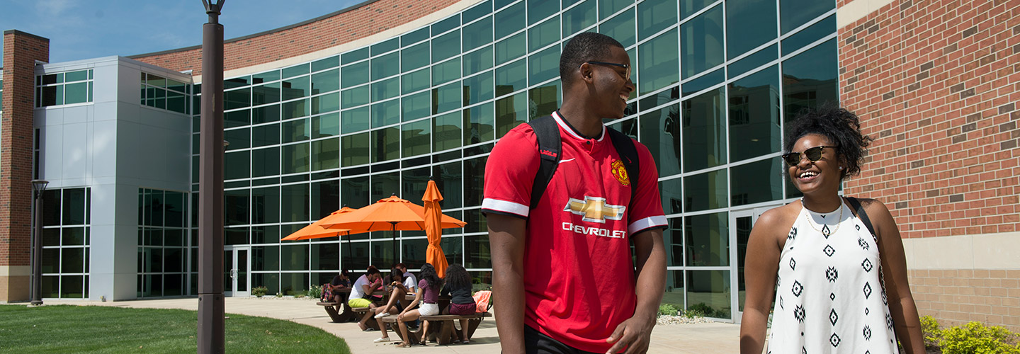 Students relaxing on campus under umbrella seating