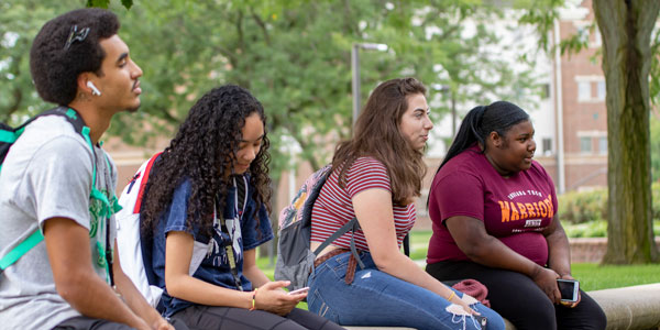 Student bridge students sitting by the water wheel