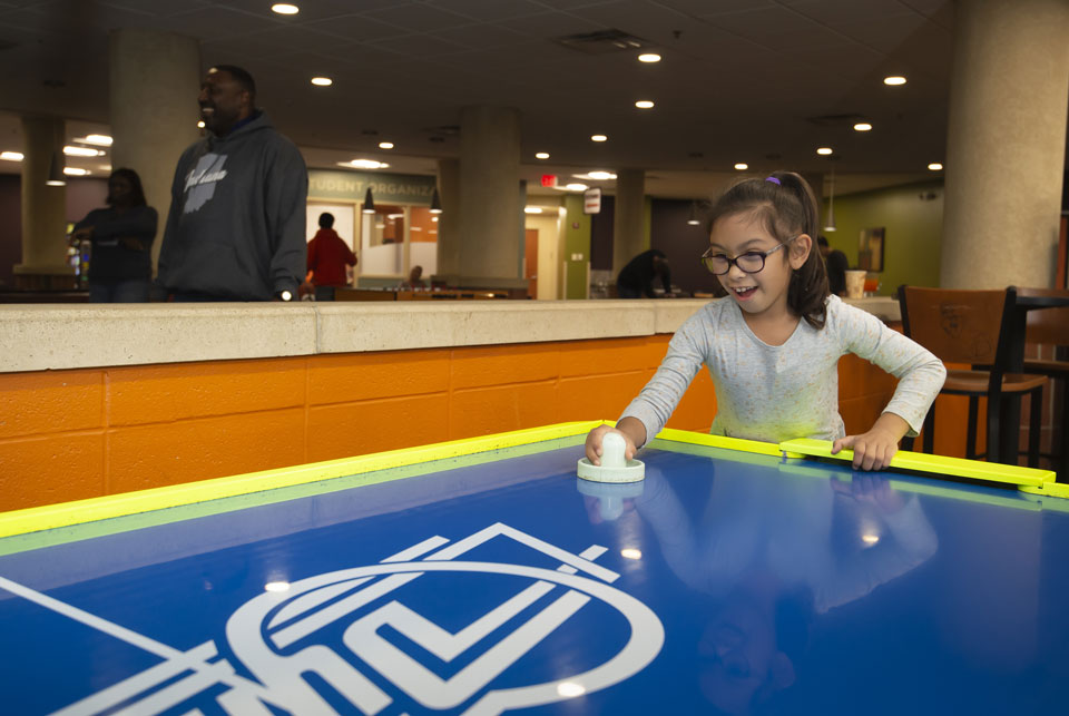 Child playing air hockey