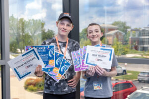 Students holding certificates of achievement