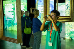 Student using camera at the Beyond Van Gogh Exhibit
