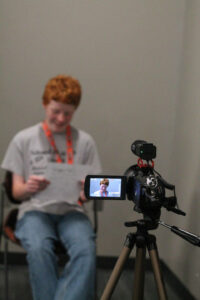 Student reading a script into a camera