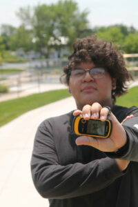 Student posing with a GPS