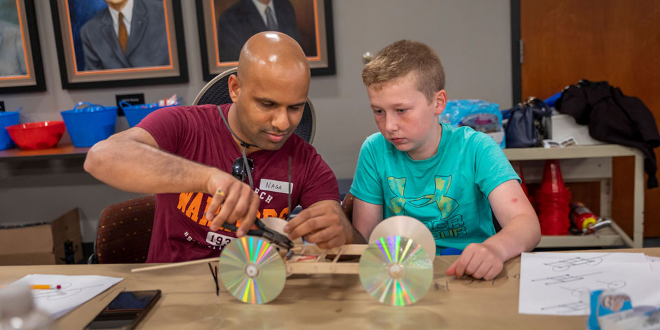 Professor and student building a CD-wheel car