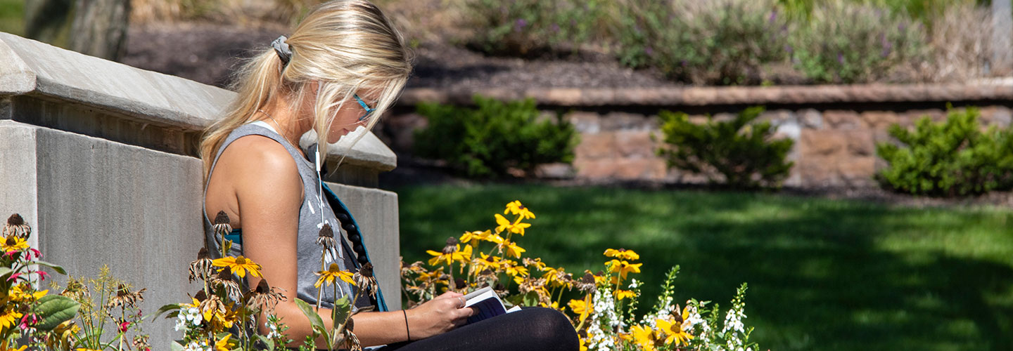 Student working next to the Indiana Tech Wheel on campus