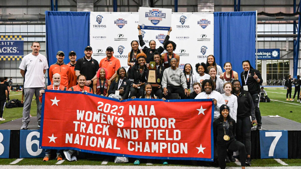 photo of 2023 women's track and field team with championship banner