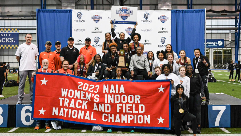 2023 track champs photo of 2023 women's track and field team with championship banner