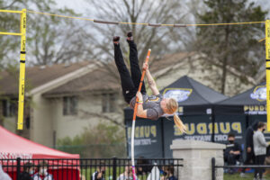 Indiana Tech student athlete clearing the bar after successfully completing a pole vault