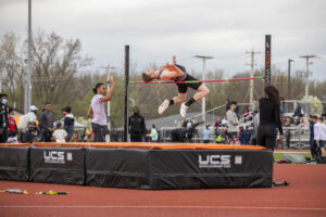 Indiana Tech student athlete clearing the bar after successfully completing a pole vault