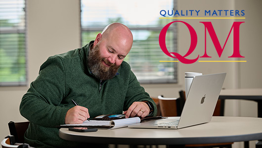 online student studying with quality matters logo overlayed over the photo