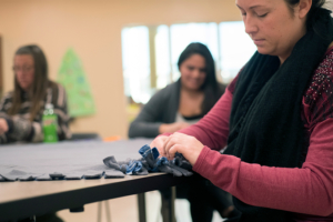 A young woman tying the ends together on a blanket