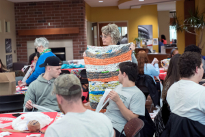 Sherrill Hamman showing students a mat created with discarded shopping bags