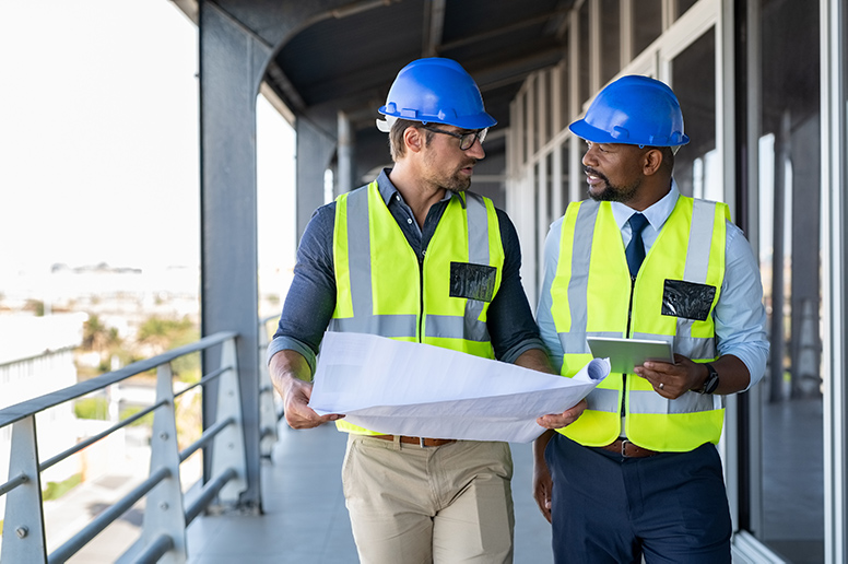 Metalworker and engineer meeting at construction site