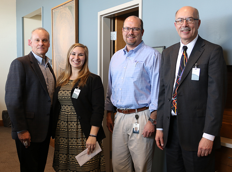 Indiana Tech mechanical engineering student Jasmine Hiss stands with, from left to right, Steven W. Aikman, vice president of Global Water Systems Engineering; Jim Volk, director of engineering for new product development; and David Aschliman, dean of Indiana Tech's College of Engineering.
