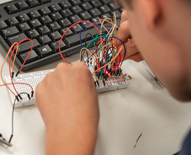 middle school camper working with electronics