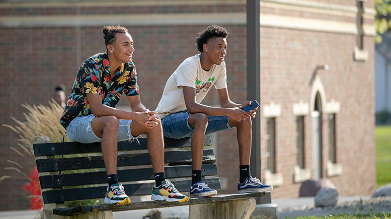New students sitting on a bench outside Andorfer Commons