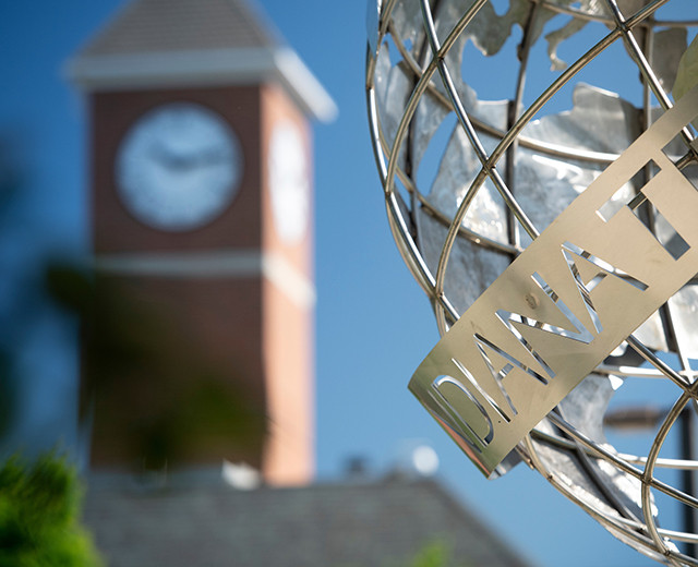 indiana Tech world sculpture with clock tower in the background